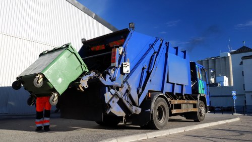 Crew member at a commercial waste collection in Hayes standing by a container